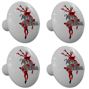 May include: Set of four white ceramic cabinet knobs with a red and black plaid reindeer design and the text "Merry Christmas".