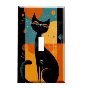 May include: A decorative light switch cover featuring a stylized black cat with orange eyes and whiskers. The cat is set against a geometric background of orange, teal, and black shapes. The cover has a glossy finish.
