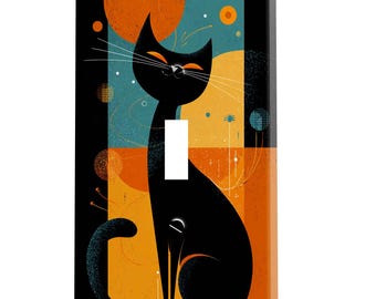 Peut inclure: Plaque d'interrupteur décorative avec un chat noir stylisé aux yeux et moustaches orange. Le chat est placé sur un fond géométrique de formes orange, turquoise et noires. La plaque a une finition brillante.