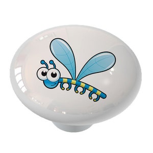 May include: A white ceramic knob with a cartoon blue dragonfly with yellow stripes and big eyes.