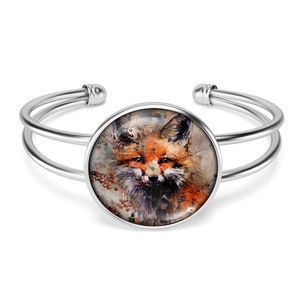 May include: Silver bangle bracelet with a round glass cabochon featuring a watercolor painting of a fox's face.