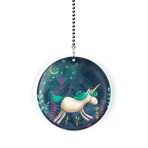 May include: A white unicorn with a teal mane and tail runs through a dark blue forest with stars and a crescent moon. The unicorn is surrounded by green and pink flowers and leaves. This is a round, white, decorative pull chain for a ceiling fan.