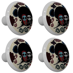 May include: Four white ceramic cabinet knobs with a colorful Day of the Dead inspired design featuring Jack Skellington and Sally from the Nightmare Before Christmas.