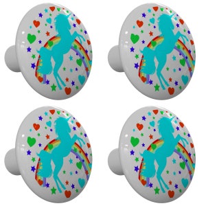 May include: Set of four ceramic cabinet knobs featuring a blue unicorn silhouette jumping over a rainbow with colorful hearts and stars on a gray background.