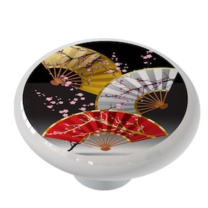 May include: Three decorative fans with a black background and pink cherry blossoms. The fans are red, gold, and white.