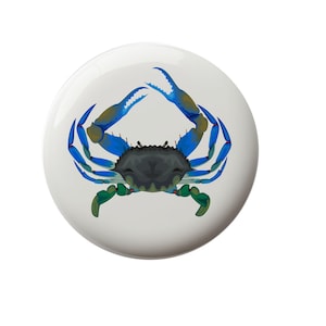 May include: A blue crab with green claws and red accents on a white background.