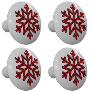 May include: Set of four white ceramic cabinet knobs with a red and black plaid snowflake design.