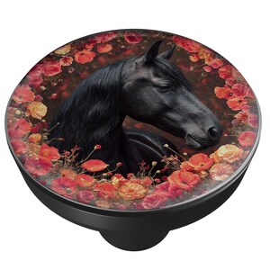 May include: A black phone grip featuring a detailed image of a black horse's head surrounded by red and orange flowers. The horse has a long, flowing mane and is set against a blurred background.