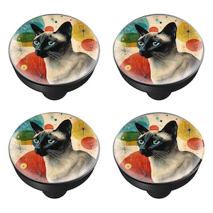 May include: Four black cabinet knobs with a Siamese cat design. Each knob features a cat portrait set against a colorful mid-century modern background with red, yellow, and blue accents. The knobs have a black base.