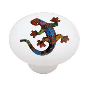 May include: A ceramic knob with a colorful painted lizard design. The lizard is orange, brown, blue, green, and yellow with black accents. The knob is white.