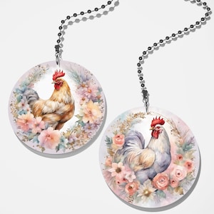 May include: Two round fan pull designs featuring watercolor illustrations of roosters surrounded by pink, white, and purple flowers. The roosters are in a wreath of greenery and have red combs.