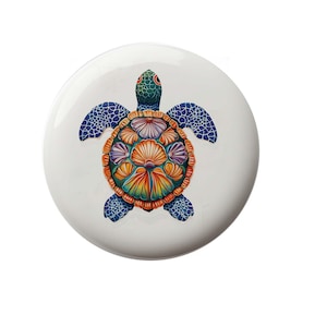 May include: A colorful ceramic turtle with a blue, green, orange, and purple shell. The turtle is painted with a floral design.