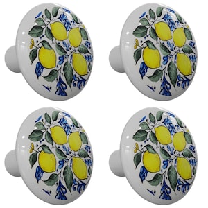 May include: Set of four white ceramic cabinet knobs with a lemon design. The knobs feature yellow lemons with green leaves and blue flowers on a white background.
