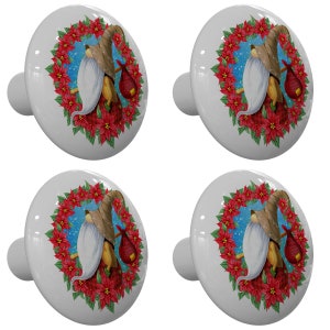 May include: Set of four white ceramic cabinet knobs. Each knob features a festive design of a gnome with a long white beard, wearing a hat and carrying a bag, surrounded by a wreath of red poinsettias against a blue snowy background.