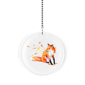 May include: A round, clear glass ceiling fan pull with a watercolor illustration of a red fox with a white chest and tail, surrounded by yellow and orange leaves.
