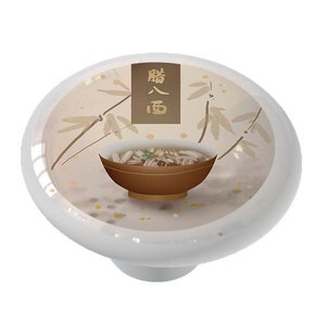 May include: A white ceramic knob with a brown bowl of noodles and the Chinese characters for "noodles" in gold on a beige background with bamboo leaves.