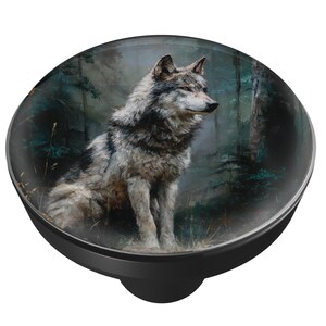 May include: A black and clear round pop-up phone grip featuring a detailed painting of a gray wolf in a forest setting. The wolf is sitting, with a focused gaze, against a backdrop of trees and foliage.