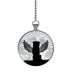 May include: A silver chain with a round pendant featuring a black silhouette of a dog with angel wings against a gray and white moonlit sky background.
