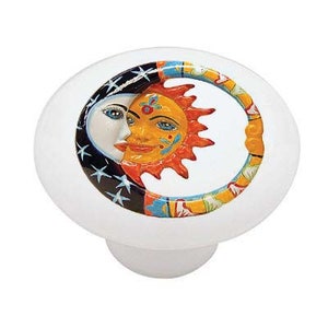 May include: Ceramic knob with a colorful design of a sun and moon. The sun is yellow with orange rays and the moon is white with blue stars.