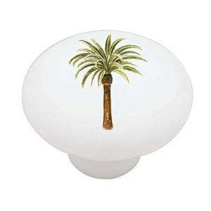 May include: A white ceramic knob with a green palm tree illustration.