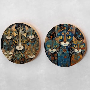 May include: Two round wooden wall plaques with colorful, abstract paintings of cats. The cats are depicted in a variety of poses and expressions, with intricate patterns and details.