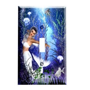 May include: A light blue and purple light switch cover with a mermaid swimming in a blue and green underwater scene with jellyfish, seaweed, and fish.
