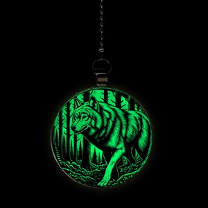 May include: A round, glow-in-the-dark pendant featuring a wolf walking through a forest. The pendant is on a black chain.