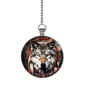 May include: A silver chain with a round pendant featuring a wolf's face inside a red and white dreamcatcher with feathers and beads.