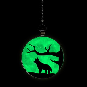 May include: A glow-in-the-dark pendant featuring a silhouette of a wolf howling at the moon with a tree branch in the background.