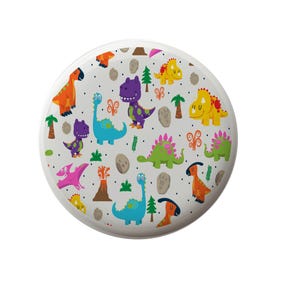 May include: A white round plate with a colorful dinosaur pattern. The dinosaurs are green, purple, orange, yellow, and pink. There are also small green palm trees and gray rocks on the plate.