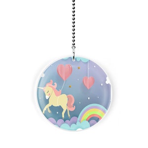 May include: A white circular ceiling fan pull with a unicorn, rainbow, and pink hearts on a blue background.