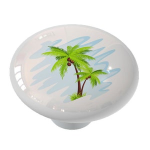 May include: A white ceramic knob with a colorful image of two palm trees with coconuts on a blue and white background.
