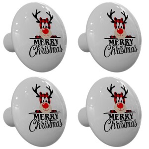 May include: Set of four white ceramic cabinet knobs with a red and black plaid reindeer peeking over the top and the words "Merry Christmas" in black lettering.