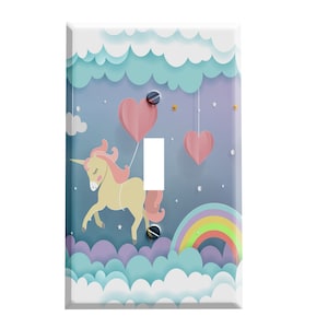 May include: A light switch cover featuring a cartoon unicorn with pink hair and a rainbow in a pastel blue sky with clouds and pink hearts.