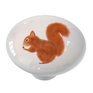 May include: A white ceramic knob with a red squirrel holding a nut. The squirrel is facing left and has a bushy tail.