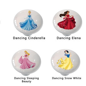 May include: Eight white ceramic knobs with images of Disney princesses in their signature ball gowns. Each knob features a different princess: Belle, Cinderella, Elena, Jasmine, Mulan, Sleeping Beauty, Snow White, and Ariel.