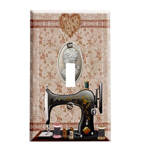 May include: A vintage-style light switch cover featuring a black sewing machine with floral details, spools of thread, and a cameo portrait on a floral patterned background.