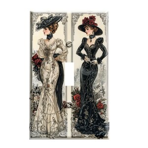 May include: Two women in vintage dresses, one in white and one in black, with elaborate hats and floral accents. The image is a light switch cover.