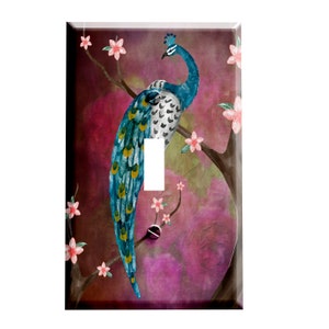 May include: A light switch cover featuring a watercolor painting of a peacock with a blue and green tail, perched on a branch with pink blossoms against a purple and pink background.
