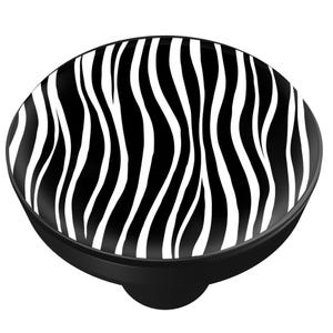 May include: A black and white zebra print phone grip. The round grip features a black base and a top surface with a bold zebra stripe pattern. The design is a classic animal print.
