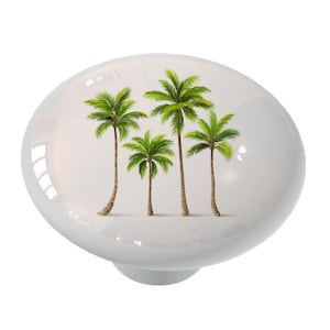 May include: A white ceramic knob with a design of four green palm trees on a white background.