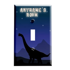 May include: A light switch cover with a blue night sky background, stars, and a silhouette of a dinosaur. The text "ANYNAME'S ROOM" is at the top of the cover.