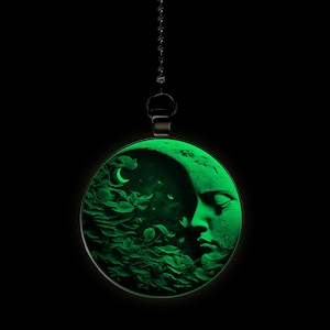 May include: A green glow-in-the-dark pendant featuring a crescent moon with a face and leaves. The pendant is hanging from a black chain.