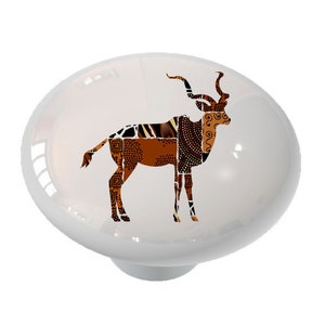 May include: A white ceramic knob with a brown and orange patterned silhouette of an antelope.