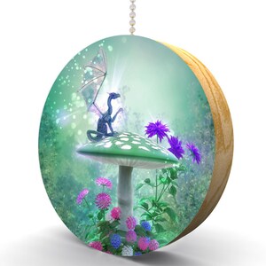 May include: A purple and blue dragon sits on a green and white mushroom with white spots. The mushroom is surrounded by pink and purple flowers in a green forest setting.