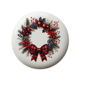 May include: A white ceramic ornament with a red and black plaid bow and a Christmas wreath with red berries, pine cones, and holly leaves.