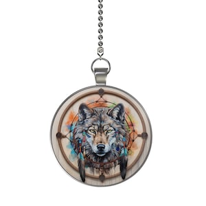 May include: A silver chain with a round pendant featuring a wolf's head inside a dreamcatcher with colorful feathers and beads. The background is a watercolor wash of orange, blue, and green.