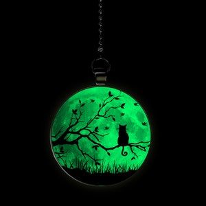 May include: A glow-in-the-dark ceiling fan pull chain with a black cat sitting on a branch in front of a full moon.