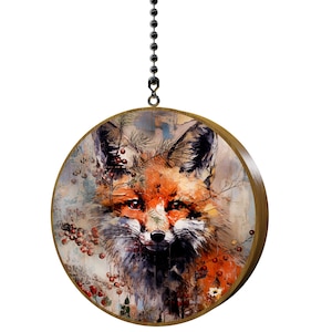 May include: Round wooden ceiling fan pull featuring a watercolor painting of a fox. The fox has orange and white fur with red eyes, surrounded by berries and branches. The pull is suspended by a metal chain.