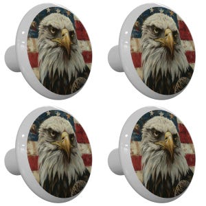 May include: Set of four ceramic cabinet knobs featuring a bald eagle with a distressed American flag background. The eagle has a fierce expression and is looking directly at the viewer.